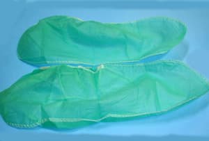 Funda de protección, hecha de dos piezas de tela sin tejer, confeccionadas mediante costura, de color azul o verde. Presenta una abertura superior que se frunce mediante una goma elástica, sujeta al borde superior mediante costura. 

Este producto se presenta como una cubierta flexible que se puede colocar sobre el calzado.