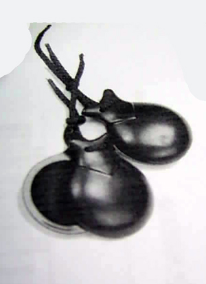 Instrumento musical de percusión, de plástico, de color negro, denominado castañuelas. Se presenta para su venta al por menor en varios tamaños.