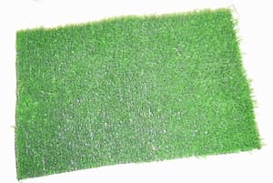 Recubrimiento para el suelo cuya materia textil (tiras de polipropileno con un ancho aparente inferior a 5 milímetros que simulan ser césped) queda al exterior una vez colocada, consta además de una base elaborada con láminas de polipropileno entrelazadas a modo de malla en la que se insertan las tiras, por medio de un proceso denominado tufting, y que una vez insertadas se recubre por su cara externa con una capa de látex. Una  vez finalizados estos procesos y en caso de ser necesario se utiliza una máquina cortadora para dar la altura deseada al “césped”. Se presenta en rollos con longitudes que van de los 5 a los 25 metros y anchos que van de 1 a 5 metros.