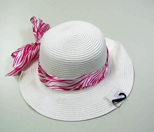 Sombrero hecho de tiras trenzadas de papel 100% unidas mediante costuras, guarnecido con una banda interior de materia textil y adornado con una cinta exterior de materia textil de 7 cm de ancho acabada en un lazo.