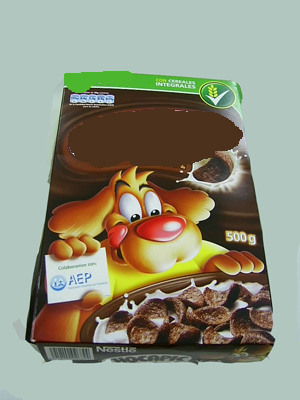 Preparación alimenticia a base de cereales tostados (trigo, predominante en peso y maíz) con chocolate. Se presenta acondicionada para la venta al por menor en caja de cartón con diferentes pesos (500g, 375 g, etc.). Su contenido de cacao es inferior al 6% en peso calculado sobre una base totalmente desgrasada y no se encuentra recubierta totalmente por chocolate.