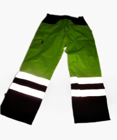 Pantalón largo confeccionado con dos tejidos de trama y urdimbre de diferentes porcentajes en algodón y poliéster. El tejido de color amarillo predomina en la mayor parte de la prenda es un 60% de algodón y un 40% poliéster. el tejido de color azul es un 65% poliéster y un 35% algodón, este último se encuentra en las piernas desde 10 cm. por debajo de la rodilla hasta los tobillos, en la cinturilla y la zona de las caderas por detrás (pieza de cinco centímetros) y la cinturilla y hasta el comienzo del forro en los dos bolsillos delanteros. El resto es de tejido amarillo con dos bolsillos traseros y uno lateral en la parte exterior de la prenda que cierran con solapa y otros dos, tipo sobre, en la parte delantera sin sistema de cierre. Tiene bragueta con cierre de cremallera, ribete protector izquierda sobre derecha, ceñido en la cintura con elástico en los costados. LLeva dos bandas reflectantes en la zona inferior de la pierta donde comienza el tejido azul .
Se presenta acondicionado conjuntamente para su venta al por menor con una prenda similar a una cazadora. No se considera un conjunto porque no están confeccionados con una sola tela. Cada artículo sigue un régimen regeneral.