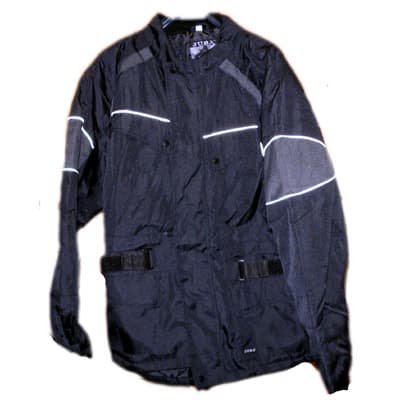 Es una prenda de tejido de trama y urdimbre de fibras sintéticas, cuyo tejido exterior, acolchado y forro es 100% poliéster. Mangas largas. Cinturón para ciñir la prenda.
Cubre la parte superior del cuerpo sin sobrepasar el medio muslo. Mas largo por detrás que por delante. Longitud total 83 cm. Peso 1110 g.
Abertura delantera completa con cierre de cremallera, con una solapa protectora de izquierda sobre derecha y se sujeta mediane corchetes. 4 bolsillos exteriores, los dos superiores tipo sobre con solapa y corchetes, los 2 inferiores tipo parche con solapa y velcro. 1 bolsillo interior tipo sobre sin cierre y una cremallera interior.