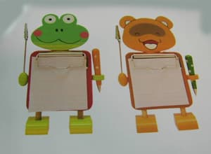 Pinza de metal común (memoclip) sujeta a una figura de madera con forma de animal, policromada. La figura a la que van sujetas las pinzas es de madera MDF (tablero de fibra de densidad media), con forma de animal, policromado. Son dos pequeñas pinzas metálicas (de unos 3 cm aproximadamente) sujetas a la figura mediante dos vástagos metálicos, para sujetar una nota, mensaje, foto, etc ... También lleva una pinza tipo clip para sujetar un pequeño bloc de notas sobre el cuerpo.

Forma de gato con patas y pies. 

Medidas de la figura incluidas las pinzas 20 cm de alto por 10 cm de ancho.