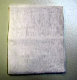 Tejido de algodón hidrófilo 100% de ligamento tafetán y peso inferior a 100g/m2. Se presenta blanqueado y con forma rectangular. Tiene unas medidas de 16x 25 cm y esta plegado en 8 capas. Se destina como gasa para apósito. 
El producto no esta acondicionada para la venta al por menor, se presenta a granel y sin esterilizar