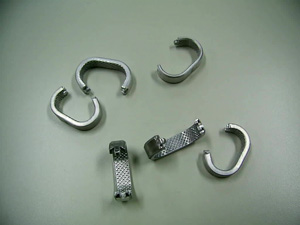 Pieza de aluminio de forma parecida a una letra C, con unas dimensiones aproximadas de 4,5 x 3x 1 cm. Presenta su cara interna gofrada, uno de sus extremos con una lengüeta y en el otro con un hueco adecuado para la lengüeta anterior. Según declaración del solicitante se destina a acoplarse por presión en la barra estabilizadora de los sistemas de suspensión de los vehículos automóviles constituyendo al final un único conjunto no desmontable.
