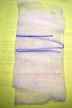 Compresa de tejido liso y poco tupido de ligamento tafetán blanqueado de 17 hilos de algodón 100%, de 24 g/m2, con hilo de contraste azul (RX), sin esterilizar, de 20x40 cm, abierta, plegada sobre sí misma varias veces resultando una compresa de de 8 capas de 10x10 cm. El producto se presenta en cajas a granel pre contadas de 10.000 ó 5.000 unidades en grupos separados por un papel entre sí de 5 unidades destinadas a ser esterilizadas y envasadas en sobres para la venta al pormenor de 5 á 20 unidades cada uno para uso quirúrgico.