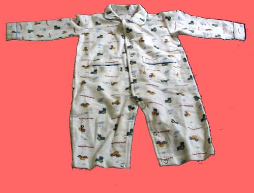Prenda de dormir de una sola pieza para bebés de, aproximadamente 63 centímetros de longitud. Elaborada con tejido de trama y urdimbre, franela 100% algodón, que cubre tanto la parte superior del cuerpo como la inferior y envuelve cada pierna separadamente dejando los pies al descubierto. Presenta mangas largas, cuello redondo, apertura frontal completa, que cierra por medio de corchetes, perneras también abiertas que se cierran por corchetes y dos bolsillos en su parte delantera