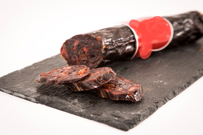 Morcilla (embutido) elaborada con carne picada, sangre coagulada y cocida, sazonada y embuchada en tripa artificial, seca, de cerdo ibérico, lista para comer directamente.
Se usa para la alimentación humana.
Carne picada de cerdo ibérico, sangre coagulada y cocida, con especias, aditivos, agua, etc., en forma de morcilla (embutido).
Se presenta envasada al vacío en bolsas individuales, en pieza.