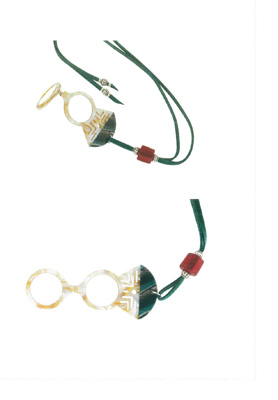 Binóculo con montura de acetato de celulosa, presentada con un cordón de ante y un abalorio de cristal.
Esta diseñado para ampliar cosas u objetos pequeños ocasionalmente por personas con presbicia.
Se inspira en distintas colecciones de joyería y ornamentos de culturas tribales africanas.
Dispone de lentes orgánicas CR39, potencia +2 dioptrías e índice de refracción 1,5.
Se presenta en un estuche con una bolsa interior.