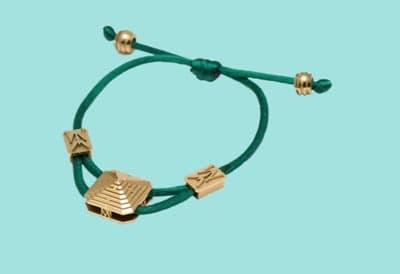 Pulsera de hilo de poliéster con cerámica de circonio (Oxido de circonio o circonia).
Está compuesta por un cordón de poliéster que atraviesa a cinco piezas cerámicas perforadas.