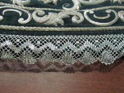 Articulo textil consistente en blondas perimetrales y encajes, elaborados mediante la técnica del encaje de bolillos. Hechos a mano.  Se utilizan hilos metálicos de oro y plata.
Se elaboran sobre una almohadilla cilíndrica utilizando distintos tipos de alfileres (alfileres de acero fino, alfileres de cabeza de vidrio de colores, punzones, separadores) y bobinas de madera (bolillos).
Tiene unas medidas que van desde 2cm de ancho hasta 25 o 30 cm el más rico y elaborado.
Se utilizan en los tapices y en los mantos y vestimentas realizados a la Virgen.
Diseño original y único.