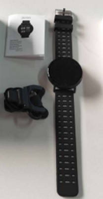 Artículo electrónico diseñado para llevarse en la muñeca como un reloj. Se presenta con esfera redonda y pulsera de silicona con unas dimensiones aproximadas son: 120 x 34 x 11 mm.
Dispone de batería recargable de 150 mAh, pantalla TFT de 0,96” y conectividad Bluetooth. Sus funciones más relevantes son: 
•	Indicador de hora. Admite configuración manual de la hora, aunque necesita una configuración inicial con un teléfono móvil. 
•	Contador de pasos.
•	Monitorización del sueño.
•	Control de la frecuencia cardiaca. 
•	Recibir notificaciones y aviso de llamadas telefónicas. 
Este artículo no puede contestar llamadas, responder mensajes ni permite hablar a través suyo
Se presenta conjuntamente con un cargador USB.
Se utiliza fundamentalmente para indicar la hora, como podómetro y como aparato de comunicación.