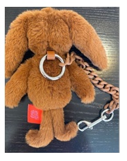 Juguete en forma de peluche, conejo. Está unido a una cadena de eslabones enganchada a un mosquetón.  La parte trasera tiene una anilla metálica para la sujeción a distintos objetos. Esta anilla puede utilizarse como llavero.
Medidas aproximadas del peluche (conejo): 20 cm de alto X 14 cm aproximadamente de ancho X 5 cm de fondo.
Según declaración de interesado tiene una función decorativa, con el objetivo de personalizar productos varios como bolsos, mochilas, carteras, llaves, etc., por su diseño y su tamaño parece estar destinados a los niños como juguete.
Composición 79% poliéster 10% aluminio 8% aleación de zinc 2% poliuretano 1% hierro. Está totalmente relleno. Relleno 100% poliéster.