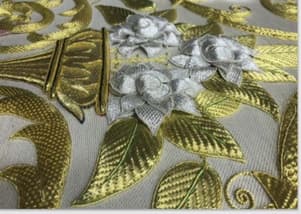 Tapiz tejido a mano consistente en un manto de Virgen que incorpora bordados con hilo de oro. Esta realizado sobre un terciopelo o tejido base en el que irá confeccionada la prenda sobre un bastidor, atirantado de nuevo con un tejido de lienzo moreno.
El bordado se realiza con hilo de oro, se utiliza hilo de seda amarillo para sujetar las puntadas del hilo de oro.  El tejido base es de terciopelo de seda natural.
Diseño original y único. Los trabajos pueden durar un par de años, realizados por varias personas.