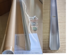 Kit presentado en envase individual de cartón con forma tubular y su correspondiente tapa de plástico, para su venta directa al por menor, compuesto por los siguientes componentes:
	Un perfil de aluminio en forma de U, de 1.950 mm de largo, 20 mm de ancho y 30 mm de alto, el cual lleva hechas hendiduras (3) necesarias para su montaje en la pared y adaptación a la mampara; 
	Dos tapas de plástico ABS para su colocación en el perfil, parte superior e inferior; 
	Una goma de presión para la fijación del cristal al perfil de 1950 mm de largo;
	8 tornillos de acero inoxidable; y 
	8 tacos de plástico para la tornillería.
Se destina para su montaje en una mampara de vidrio.
El perfil de aluminio tiene partes abiertas y constituye el elemento principal del kit al utilizarse como base para sujetar la hoja de vidrio y a su vez fijar está a la pared.
Contenido de aluminio inferior al 99%.