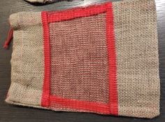Saco de yute 100% natural, reciclable y biodegradable (tejido bruto sin ningún tipo de laminación o tratamiento). Dispone de cordón del mismo tejido en la parte superior del saco para fruncir y de una ventana de ventilación por una sola cara en el centro de del saco, dicha ventana es de algodón o plástico rojo reciclable. No son usados.
Tiene unas medidas de 22x31cm y una capacidad de 1,5 kg.
Se utiliza para el envasado de frutas y verduras únicamente, especialmente cítricos. Normalmente en campañas.
