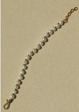 Artículo de adorno personal, pulsera de perlas cultivadas con broche y cadena alargadora de latón macizo. Las perlas van una a una anudadas con hilo.
Se utiliza como objeto de adorno personal.