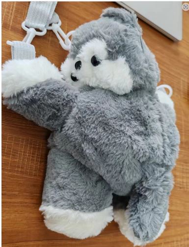 Mochila con la superficie exterior de materia textil (poliéster). Está diseñada para llevar a la espalda mediante dos correas, o llevarla tipo bandolera. Dispone de compartimento para guardar pequeños objetos. Tiene forma de animal y presenta relleno de poliéster para dar forma a las distintas del animal. 
Se presenta para su venta al público en cajas con cuatro unidades cada una de ellas.
Las correas son de poliéster y los mosquetones y anillas de PVC
Se utiliza para transportar en su interior distintos artículos.