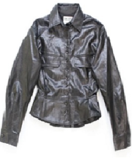 Según declaración del solicitante se trata de una cazadora. Cubre la parte superior del cuerpo y desciende hasta la cintura. Tiene una abertura completa delantera que se cierra con cremallera oculta tras doble solapa con doce botones de ojal. Presenta cuello camisero y mangas largas que se ajustan al puño con botón de ojal.  Dispone de dos solapas en el pecho, meramente de adorno. El bajo está adornado con un volante peplum. Está concebida para ser llevada encima de otra prenda.
Función o uso: Se utiliza como prenda de vestir.
Está confeccionada en plástico celular (poliuretano), con un tejido base 71% viscosa, 15% poliéster, 9% algodón, 5% fibra metálica y forro 100% poliéster. La capa textil es un mero soporte que no ha sido sometido a trabajos más avanzados.
