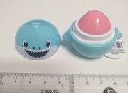 Brillo labial sólido de tono rosado.
Se utiliza como maquillaje.
El producto se presenta como un envase compacto y rígido de plástico moldeado, en forma de tiburón de color azul. El diseño incluye una tapa roscada que se abre para permitir el acceso al contenido interior. El envase tiene un tamaño de aproximadamente 45 cm de diámetro.