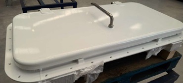Puertas y escotillas navales (puertas colocadas en posición vertical y horizontal respectivamente en las embarcaciones) fabricadas en material de aluminio con espesores de chapa de puerta de 4, 5, 6 u 8 mm. Están provistas de marco, bisagras, palanca, etc. Disponen de un perfil esponjoso o frisa de EPDM para la estanqueidad de la puerta, en algunos casos de lana de roca como aislante térmico, de ventanas con vidrio y, dependiendo del diseño de la puerta, de elementos de apertura neumática como pistones. Se pueden presentar con acabados granallados, imprimados y/o pintados.