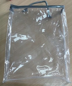 Artículo fabricado de láminas de plástico no celular (PVC). Sus dimensiones aproximadas son de 43 x 37 x 15 cm (largo, ancho, alto). El producto es completamente transparente, una cremallera para cerrarlo en un lado y un asa hecha con un cordón de materia textil sujeto mediante dos agujeros y una pieza de plástico, en el mismo lado donde se encuentra la cremallera. Se abre para formar un bolso de forma rectangular.
Función y uso:
Se utiliza, por ejemplo, para guardar prendas de vestir o ropa de hogar.
Composición. PVC.