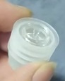 Dispositivo de cierre de plástico dosificador con sistema de válvula antirretorno diseñado para ser acoplado a presión en el cuello de botellas de vidrio.
Presenta un cuerpo exterior cilíndrico con estrías laterales de sellado fabricado íntegramente en plástico de grado alimentario, material que le otorga su carácter esencial al permitir el ajuste mecánico y la función de cierre del envase. En su interior incorpora una válvula de seguridad compuesta por una esfera de vidrio de grado alimentario que actúa por gravedad, permitiendo la salida controlada del líquido durante el vertido y bloqueando el rellenado de la botella una vez situada en posición vertical.
El uso principal de la mercancía es la dosificación precisa y la protección de la integridad del contenido en el envasado de licores.