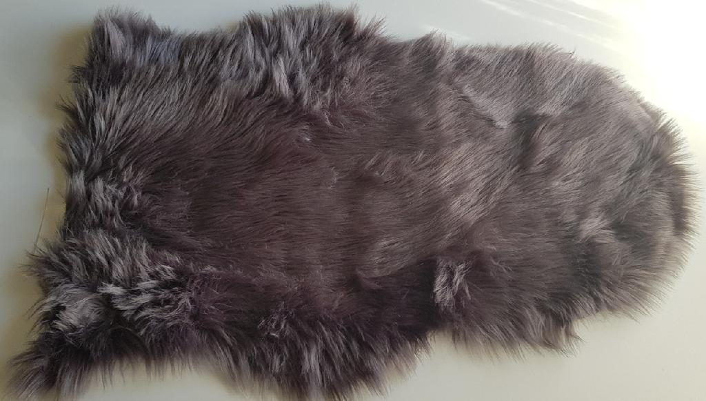 Kyseessä oleva tavara on tekstiilistä valmistettu lampaantalja-jäljitelmä. Tavara on suurimmilta mitoiltaan 50 x 80 cm.  Asiakkaan toimittamien tietojen mukaan materiaali on 100 % akryylia. Tavara on valmistettu kahdesta erilaisesta tekstiilikankaasta. Päällimmäinen kangas on nukkaneulosta ja se on kiinnitetty toiseen tukevampaan tekstiilikankaaseen. Tavara on sovitettu. Tavaralla on tekstiiliaineesta valmistetun lattianpäällysteen tunnusmerkit.