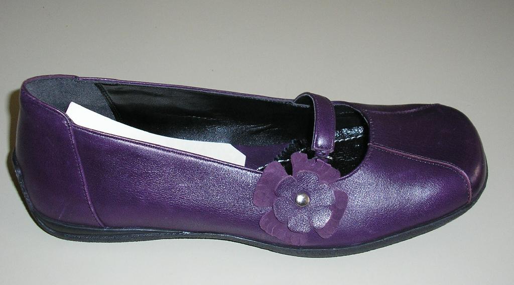 CHAUSSURE, POUR FEMMES, À SEMELLE EXTÉRIEURE EN CAOUTCHOUC (ÉLASTOMÈRE) ET DESSUS EN CUIR NATUREL, NE COUVRANT PAS LA CHEVILLE ET MUNIE D'UNE SEMELLE INTÉRIEURE D'UNE LONGUEUR SUPÉRIEURE À 24 CM.
CETTE CHAUSSURE EST DE TYPE BALLERINE AVEC UN BOUT PLUTÔT CARRÉ. 

ELLE COMPORTE UNE BRIDE ÉLASTIQUÉE AU NIVEAU DU COU DE PIED ET UNE FLEUR DÉCORATIVE SUR LE CÔTÉ EXTÉRIEUR.

EN OUTRE LA SEMELLE EXTÉRIEURE REMONTE SUR LE TALON ET PRÉSENTE UNE GRAVURE REPRÉSENTANT UNE FLEUR.