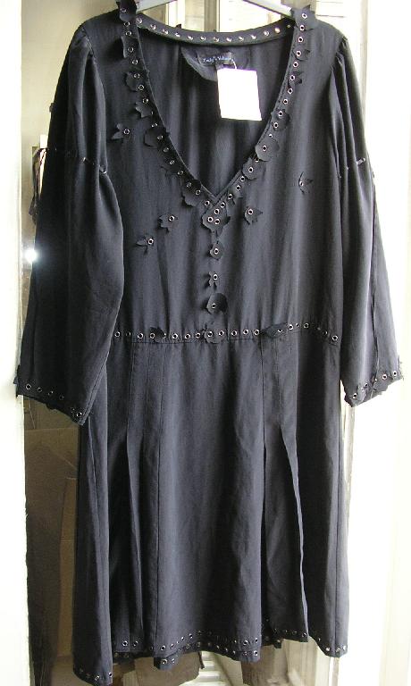 ROBE EN TISSU DE SOIE, DESCENDANT AU NIVEAU DU GENOU, AVEC DES MANCHES LONGUES, AVEC UNE ENCOLURE EN V, AVEC UN OURLET À LA BASE ET À L'EXTRÉMITÉ DES MANCHES.

LES BORDURES DE LA BASE, DE L'ENCOLURE, DE L'EXTRÉMITÉ DES MANCHES, ET LA TAILLE SONT SOULIGNÉS PAR DES RIVETS DÉCORATIFS.