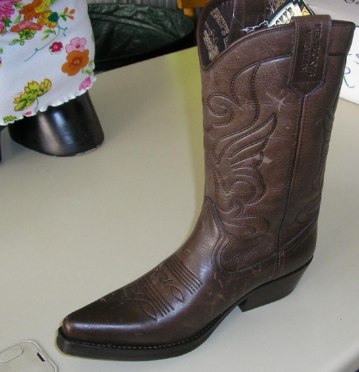 BOTTE WESTERN, NON RECONNAISSABLE COMME ETANT POUR HOMME OU POUR FEMME, AVEC RENFORT AU TALON, DONT LE DESSUS EST EN CUIR, LA DOUBLURE EST EN MATIERE TEXTILE, LA SEMELLE EXTERIEURE EST EN CAOUTCHOUC DITE "ELASTOMERE" ET MESURE PLUS DE 24 CM, DECORATION SURPIQURES APPARENTES ET PATTES, LOGO PUBLICITAIRE IMPRIME SUR LES PATTES.