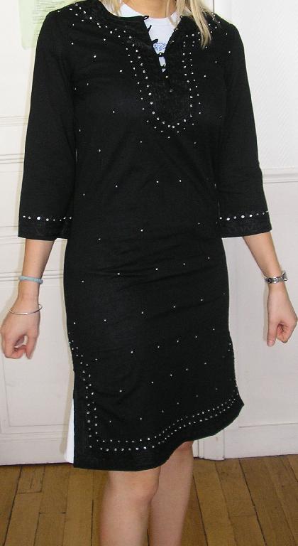 ROBE EN TISSU DE COTON DESCENDANT AU DESSUS DU GENOU (LONGUEUR 96 CM), AVEC DES MANCHES 3/4, AVEC UNE OUVERTURE PARTIELLE AU COL SE FERMANT PAR DE PETITS BOUTONS, AVEC DES FENTES D'UNE LONGUEUR DE 18 CM SUR LE BAS DES COTÉS, AVEC DES FENTES D'UNE LONGUEUR DE 8 CM À L'EXTRÉMITÉ DES MANCHES.

L'ARTICLE PRÉSENTE DES BRODERIES ET DE PERLES COUSUES EN LIGNE SUR LE POURTOUR DE LA BASE, DE L'EXTRÉMITÉ DES MANCHES ET DE L'ENCOLURE.