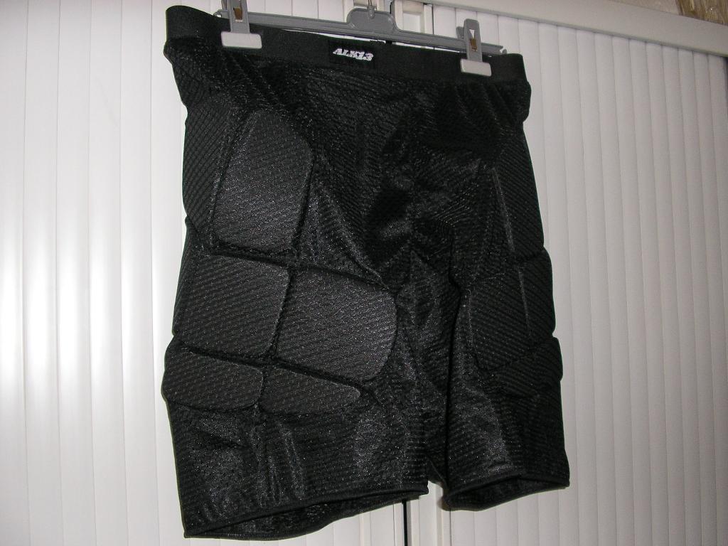 VETEMENT DESTINE A RECOUVRIR LE BAS DU CORPS, GENRE CALECON, POUR HOMME, EN ETOFFE DE BONNETERIE SYNTHETIQUE, COMPORTANT UNE TAILLE ELASTIQUEE, DES RENFORTS EN POLYETHYLENE POUR LA PROTECTION DES HANCHES ET DU COCCYX, LA BASE DES CUISSES EST ELASTIQUEE, LOGO PUBLICITAIRE COUSU DEVANT SUR LA CEINTURE, CE VETEMENT EST DESTINE A ETRE PORTE SOUS UN AUTRE VETEMENT POUR LA PRATIQUE DU ROLLER OU DU SKATE BOARD.