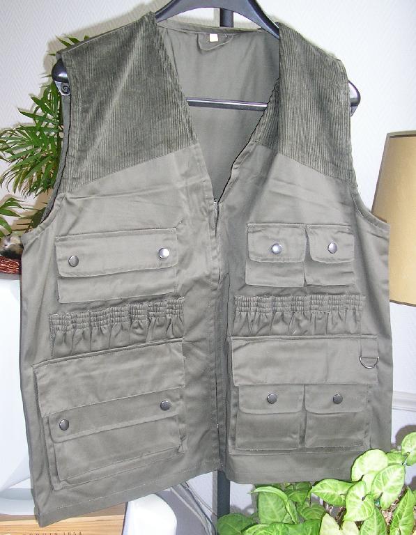 ENSEMBLE POUR HOMME COMPOSE D’UN HAUT GENRE GILET ET D’UN PANTALON, CONFECTIONNÉS EN TISSU DE FIBRES SYNTHÉTIQUES (65% POLYESTER- 35% COTON) :
- GILET, DESTINE A COUVRIR LA PARTIE SUPERIEURE DU CORPS, DESCENDANT SOUS LES HANCHES, SANS MANCHES, AVEC UNE ENCOLURE EN V, AVEC UNE OUVERTURE COMPLETE SUR LE DEVANT SE FERMANT A L’AIDE D'UNE FERMETURE À GLISSIÈRE, SANS DOUBLURE, AVEC AU NIVEAU DE LA POITRINE A DROITE : UNE POCHE A SOUFFLET MUNIE D’UN RABAT SE FERMANT PAR BOUTONS -PRESSION, A GAUCHE : DEUX PETITES POCHES A SOUFFLET MUNIES D’UN RABAT SE FERMANT PAR BOUTONS-PRESSION. AU NIVEAU DE LA TAILLE DES PETITES CARTOUCHIERES. AU NIVEAU DES HANCHES DEUX GRANDES POCHES MUNIES D’UN RABAT. LA POCHE DE DROITE POSSEDE UNE POCHE SUPERPOSEE, LA POCHE DE GAUCHE POSSEDE DEUX PETITES POCHES SUPERPOSEES MUNIES CHACUN D’ELLES D’UN RABAT SE FERMANT A L’AIDE DE BOUTONS-PRESSION, AVEC UNE POCHE INTERNE SE FERMANT A L’AIDE D’UNE FERMETURE A GLISSIERE ET DANS LE DOS UNE POCHE GIBECIERE, AVEC UN OURLET A LA BASE.
- PANTALON POUR HOMME, DESCENDANT JUSQU'AUX CHEVILLES, AVEC UNE OUVERTURE PARTIELLE SUR LE DEVANT SE FERMANT GAUCHE SUR DROITE PAR BOUTON ET UNE FERMETURE A GLISSIERE DISSIMULEE SOUS UNE PATTE DE PROTECTION FORMANT BRAGUETTE, AVEC DES PASSANTS A LA TAILLE, AVEC DEUX POCHES LATERALES SUR LE DEVANT AU NIVEAU DES HANCHES, AVEC DANS LE DOS DEUX POCHES MUNIES D’UN RABAT SE FERMANT PAR BOUTONS ET UNE PETITE POCHE AU BAS DE LA POCHE DROITE, AVEC UNE FENTE DE CHAQUE COTE DE 25 CM ENVIRON SE FERMANT PAR UNE FERMETURE A GLISSIERE, AVEC UN OURLET A LA BASE.
LE GILET ET LE PANTALON SONT GARNIS D’UN TISSU EN VELOURS COTELE.