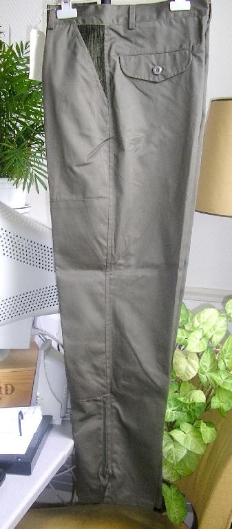 ENSEMBLE POUR HOMME EN TISSU DE FIBRES SYNTHETIQUES (65% POLYESTER – 35% COTON) COMPOSE :
- D'UNE VESTE, DESTINEE A RECOUVRIR LA PARTIE SUPERIEURE DU CORPS, DESCENDANT JUSQU’AUX HANCHES, AVEC UN COL, AVEC DES MANCHES LONGUES POURVUES A LEURS EXTREMITES D’UN OURLET, AVEC UNE OUVERTURE COMPLETE SUR LE DEVANT SE FERMANT PAR UNE FERMETURE A GLISSIERE DISSIMULEE SOUS UNE PATTE DE PROTECTION SE FERMANT GAUCHE SUR DROITE PAR DES BOUTONS-PRESSION, AVEC DEUX POCHES LATERALES AU NIVEAU DE LA POITRINE, AVEC AU NIVEAU DE LA TAILLE DES PETITES CARTOUCHIERES, AVEC AU NIVEAU DES HANCHES DEUX GRANDES POCHES MUNIES D’UN RABAT. LA POCHE DE DROITE POSSEDE UNE POCHE SUPERPOSEE, LA POCHE DE GAUCHE POSSEDE DEUX PETITES POCHES SUPERPOSEES MUNIES CHACUNE D’ELLES D’UN RABAT SE FERMANT A L’AIDE DE BOUTONS-PRESSION, AVEC A L’INTERIEUR UNE POCHE SE FERMANT A L’AIDE D’UNE FERMETURE A GLISSIERE ET UNE PETITE POCHE TELEPHONE SE FERMANT PAR RABAT POURVU DE VELCRO, AVEC DANS LE DOS UNE POCHE GIBECIERE SE FERMANT PAR BOUTONS-PRESSION, AVEC UNE FINE DOUBLURE EN TISSU DE FIBRES SYNTHETIQUES, AVEC UN OURLET A LA BASE.
- D’UN PANTALON, DESCENDANT JUSQU'AUX CHEVILLES, SANS DOUBLURE, AVEC UNE CEINTURE DE 3,5 CM ENVIRON COMPORTANT CINQ PASSANTS ET UN BOUTON, AVEC UNE OUVERTURE PARTIELLE SUR LE DEVANT SE FERMANT GAUCHE SUR DROITE PAR UNE FERMETURE A GLISSIERE DISSIMULEE SOUS UNE PATTE DE PROTECTION FORMANT BRAGUETTE, AVEC AU NIVEAU DES HANCHES DEUX POCHES LATERALES SUR LE DEVANT, AVEC DANS LE DOS DEUX POCHES MUNIES D’UN RABAT SE FERMANT PAR BOUTONS ET UNE PETITE POCHE AU DESSOUS DE LA POCHE DROITE, AVEC AU BAS DU PANTALON UNE FENTE DE CHAQUE COTE DE 25 CM ENVIRON SE FERMANT PAR UNE FERMETURE A GLISSIERE, AVEC UN OURLET A LA BASE.
LA VESTE ET LE PANTALON SONT GARNIS SUR LE DEVANT D’UN EMPIECEMENT EN VELOURS COTELE.