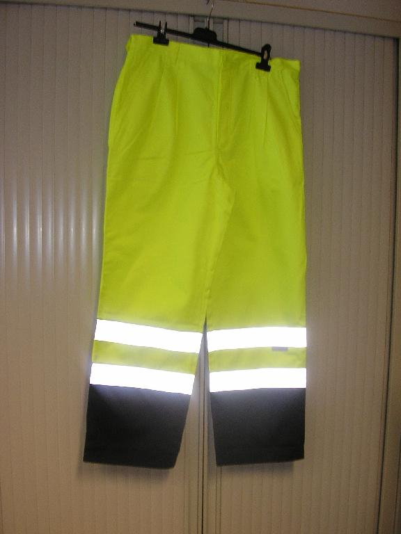 PANTALON DE TRAVAIL, FLUORESCENT, POUR HOMMES, EN TISSU 60% COTON ET 40% POLYESTER, COMPORTANT UNE TAILLE AVEC BOUTON ET PASSANTS, UNE BRAGUETTE AVEC BOUTONS ET RABAT DE GAUCHE SUR DROITE, UNE GRANDE POCHE DE CHAQUE COTE DU VETEMENT AU NIVEAU DES HANCHES, UNE POCHE AVEC RABAT ET BANDE VELCRO AU NIVEAU DES FESSES, UNE PETITE POCHE SUR LE COTE DROIT AU NIVEAU DE LA CUISSE, BANDES REFLECHISSANTES AU BAS DES JAMBES, LA BASE DU VETEMENT EST OURLEE, LOGO COMMERCIAL COUSU SUR LA JAMBE GAUCHE DEVANT.