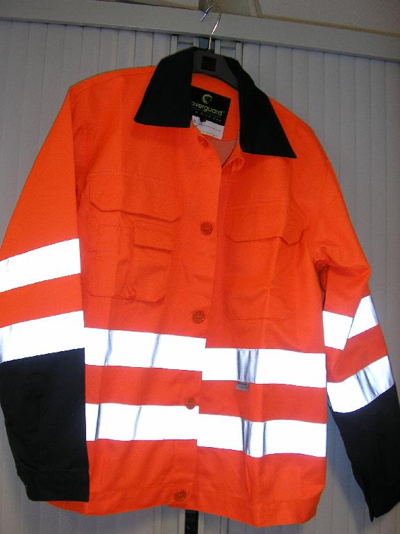 VETEMENT DESTINE A RECOUVRIR LE HAUT DU CORPS, GENRE VESTE, POUR HOMME, EN TISSU 60% COTON ET 40% POLYESTER, COMPORTANT UN COL CHEMISIER, DES MANCHES LONGUES DONT LES EXTREMITES ONT UN BOUTON, UNE OUVERTURE COMPLETE SUR LE DEVANT AU MILIEU AVEC UN RABAT DE PROTECTION ET DES BOUTONS SE REFERMANT DE GAUCHE SUR DROITE, UNE POCHE POITRINE AVEC FERMETURE PAR BANDE VELCRO AU NIVEAU DE LA POITRINE COTE GAUCHE, UNE POCHE POITRINE AVEC PETITE POCHE ET EMPLACEMENTS STYLO ET FERMETURE PAR BANDE VELCRO COTE DROIT AU NIVEAU DE LA POITRINE, DEUX BANDES DE TISSU REFLECHISSANT AU NIVEAU DE LA TAILLE ET DES HANCHES DOS, FACE ET MANCHES DU VETEMENT, LA BASE SE TERMINE PAR UNE BANDE DE TISSU AVEC UN BOUTON.