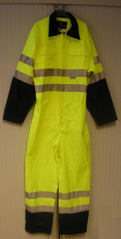 COMBINAISON DE TRAVAIL, EN TISSU DE COTON (65% COTON - 35% POLYESTER), TEINT DE COULEUR FLUORESCENTE, NON RECONNAISSABLE COMME ÉTANT POUR HOMMES OU POUR FEMMES, RECOUVRANT LES PARTIES SUPÉRIEURE ET INFÉRIEURE DU CORPS, DESCENDANT JUSQU'AUX CHEVILLES.
CE VÊTEMENT COMPORTE UN COL, UNE OUVERTURE PARTIELLE SUR LE DEVANT DESCENDANT JUSQU'À L'ENTRE-JAMBE ET SE FERMANT PAR UNE FERMETURE À GLISSIÈRE, DES MANCHES LONGUES COMPORTANT DES POIGNETS AVEC BOUTONNAGE, DES POCHES POITRINE À SOUFFLET AVEC RABAT MUNI DE VELCRO, UNE TAILLE ÉLASTIQUÉE DANS LE DOS ET DEUX POCHES PLAQUÉES SITUÉES AU NIVEAU DES HANCHES. L'INTÉRIEUR DU COL, LA PARTIE DES MANCHES ALLANT DU COUDE AU POIGNET ET L'EXTRÉMITÉ DES JAMBES SONT CONFECTIONNÉS DANS UN TISSU DE COULEUR CONTRASTÉE.

ENFIN CE VÊTEMENT PRÉSENTE DES BANDES RÉTRORÉFLÉCHISSANTES ET UN OURLET À L'EXTRÉMITÉ DES JAMBES.