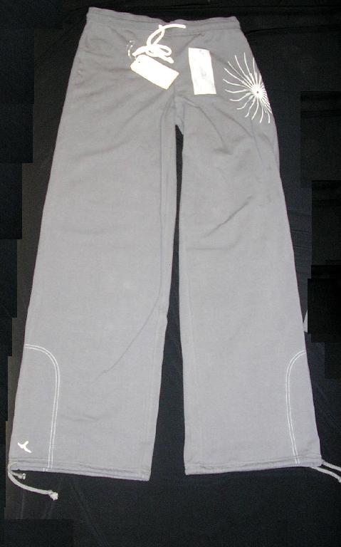 SURVÊTEMENT DE SPORT EN ÉTOFFE DE BONNETERIE MAJORITAIREMENT DE COTON (92% COTON - 8% ÉLASTHANNE), NON DOUBLÉ, COMPOSÉ DE DEUX PIÈCES : 

- UN GILET, TEINT UNIFORMÉMENT, DESCENDANT JUSQU'AU-DESSOUS DE LA TAILLE,  AVEC UN COL RAPPORTÉ EN BORD-CÔTE DE COULEUR CONTRASTÉE, AVEC UNE OUVERTURE COMPLÈTE SUR LE DEVANT SE FERMANT À L'AIDE D'UNE FERMETURE À GLISSIÈRE, AVEC DES MANCHES LONGUES MUNIES D'UN BORD-CÔTE À LEUR EXTRÉMITÉ ET AVEC DEUX POCHES FENDUES LATÉRALES SITUÉES AU-DESSUS DE LA TAILLE. 
EN OUTRE, CE GILET PRÉSENTE DES DESSINS IMPRIMÉS (FIGURES GÉOMÉTRIQUES) SUR CHAQUE MANCHE DU COUDE AU POIGNET, UN GALON EN BORD-CÔTE SUR LE POURTOUR DES POCHES ET UN BORD-CÔTE RAPPORTÉ À LA BASE.

- UN PANTALON, TEINT UNIFORMÉMENT, DESCENDANT JUSQU'AUX CHEVILLES, DE COUPE DROITE, TENU À LA TAILLE PAR UNE LARGE BANDE ÉLASTIQUE ET UN CORDON COULISSANT, SANS OUVERTURE À LA TAILLE, NI POCHES.
IL PRÉSENTE UN DESSIN IMPRIMÉ (SIMILAIRE AUX DESSINS DU GILET) SUR LE HAUT DE LA JAMBE GAUCHE ET COMPORTE UN OURLET AINSI QU'UN CORDON COULISSANT RESSERRANT À L'EXTRÉMITÉ DE CHAQUE JAMBE.