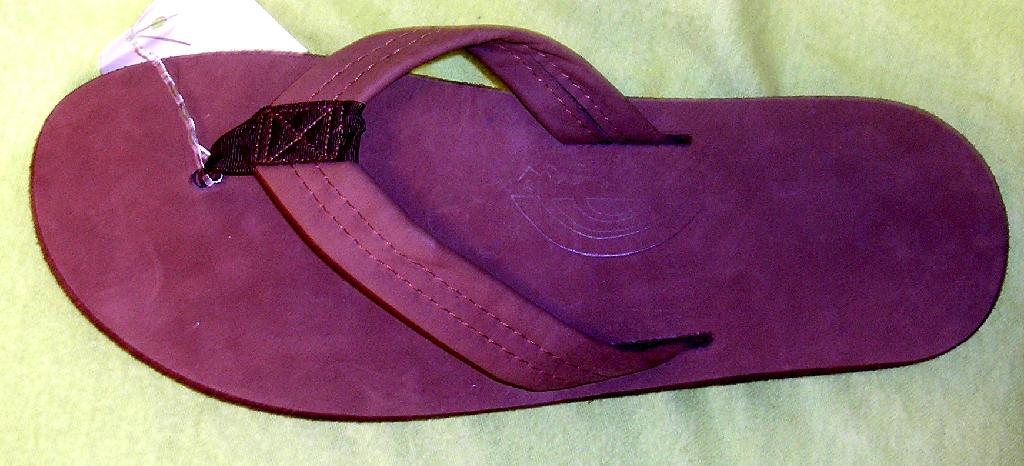 CHAUSSURE SANDALE, DE TYPE TONG, NON RECONNAISSABLE COMME ÉTANT POUR HOMMES OU POUR FEMMES, À SEMELLE EXTÉRIEURE EN MATIÈRE PLASTIQUE (EVA) ET AVEC DESSUS EN CUIR NATUREL.

LE DESSUS EST CONSTITUÉ D'UNE LANIÈRE EN CUIR FIXÉE EN TROIS POINTS À LA SEMELLE DONT UN ENTRE LE POUCE ET LES AUTRES ORTEILS.

LA SEMELLE INTÉRIEURE EST EN CUIR ET PRÉSENTE UNE LONGUEUR SUPÉRIEURE À 24 CM.
