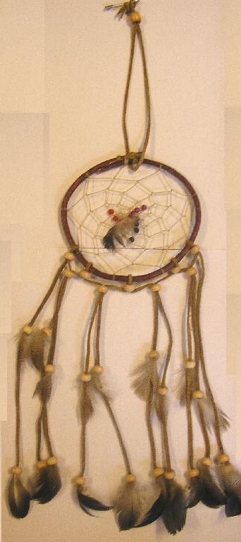 OBJET D'ORNEMENTATION, DÉNOMMÉ "CAPTEUR DE RÊVES", CONSISTANT EN UN CERCLE RIGIDE EN BOIS PRÉSENTANT SUR SON POURTOUR DES LANIÈRES DE CUIR SUR LESQUELLES SONT ENFILÉES DES PERLES ET DES PLUMES.

CET ARTICLE EST DESTINÉ À ÊTRE SUSPENDU AU MOYEN D'UNE LANIÈRE EN CUIR.