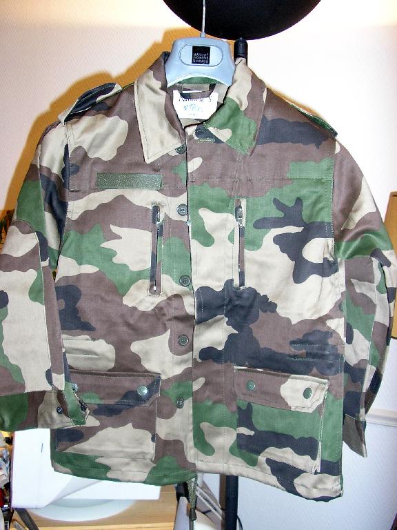 ENSEMBLE POUR GARCONNET EN TISSU DE COTON (100% COTON) STYLE TISSU CAMOUFLAGE COMPOSE :

- D'UNE VESTE, DESTINEE A RECOUVRIR LA PARTIE SUPERIEURE DU CORPS, DESCENDANT JUSQU’AUX HANCHES, AVEC UN COL, AVEC UNE PATTE DE CHAQUE COTE AUX EPAULES SE FERMANT PAR BOUTONS, AVEC DES MANCHES LONGUES POURVUES A LEURS EXTREMITES D’UNE POIGNEE SE FERMANT PAR BOUTONS-PRESSION ET D’UN RENFORT DESCENDANT DU COUDE AU POIGNET, AVEC UNE OUVERTURE COMPLETE SUR LE DEVANT SE FERMANT PAR UNE FERMETURE A GLISSIERE DISSIMULEE SOUS UNE PATTE DE PROTECTION SE FERMANT GAUCHE SUR DROITE PAR BOUTONS, AVEC UNE BANDE VELCRO ET DEUX POCHES LATERALES AU NIVEAU DE LA POITRINE SE FERMANT A L’AIDE D’UNE FERMETURE A GLISSIERE, AVEC AU NIVEAU DES HANCHES DEUX POCHES PLAQUEES A SOUFFLET MUNIES D’UN RABAT SE FERMANT PAR BOUTONS-PRESSION, AVEC UN CORDON COULISSANT A LA TAILLE, SANS DOUBLURE, AVEC UN OURLET A LA BASE MUNI D’UN CORDON COULISSANT RESSERRANT.

- D’UN PANTALON, DESCENDANT JUSQU'AUX CHEVILLES, AVEC UN ELASTIQUE A LA TAILLE, AVEC UNE OUVERTURE PARTIELLE SUR LE DEVANT SE FERMANT GAUCHE SUR DROITE PAR UN BOUTON ET UNE FERMETURE A GLISSIERE DISSIMULEE SOUS UNE PATTE DE PROTECTION FORMANT BRAGUETTE, AVEC AU NIVEAU DES HANCHES DEUX POCHES LATERALES SUR LE DEVANT, AVEC UNE POCHE DE CHAQUE COTE AU NIVEAU DES CUISSES MUNIES D’UN RABAT DE PROTECTION SE FERMANT PAR BOUTONS-PRESSION, AVEC UN OURLET A LA BASE MUNI D’UN CORDON COULISSANT RESSERRANT.

TAILLE 8 ANS