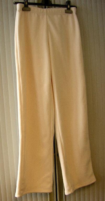 SURVÊTEMENT DE SPORT NON RECONNAISSABLE COMME ÉTANT POUR HOMMES OU POUR FEMMES EN ÉTOFFE DE BONNETERIE DE FIBRES SYNTHÉTIQUES (100% POLYESTER) GRATTÉE DE TYPE POLAIRE, NON DOUBLÉ, COMPOSÉ DE DEUX PIÈCES : 

-  UN PULL-OVER DESCENDANT JUSQU'AUX HANCHES AVEC UN COL MONTANT, UNE OUVERTURE PARTIELLE À L'ENCOLURE DESCENDANT EN BIAIS VERS LA MANCHE GAUCHE SE FERMANT AUX MOYEN D'UNE FERMETURE À GLISSIÈRE, DES MANCHES LONGUES RESSERRÉES À LEUR EXTRÉMITÉ PAR UN BIAIS ÉLASTIQUE DE COULEUR CONTRASTÉE ET UN OURLET À LA BASE. 
EN OUTRE, CE VÊTEMENT PRÉSENTE UNE DOUBLURE AU COL DE COULEUR CONTRASTÉE, UNE BRODERIE FIGURANT UN LOGO PUBLICITAIRE SUR LA MANCHE DROITE, DES BRODERIES FIGURANT DES FLEURS SUR L'ÉPAULE GAUCHE, PLUSIEURS EMPIÈCEMENTS DE COULEUR CONTRASTÉE AU NIVEAU DES MANCHES ET DES EMMANCHURES, DES PARTIES LÉGÈREMENT REMBOURRÉES AU NIVEAU DES ÉPAULES ET DES AVANT-BRAS ET UN GAUFRAGE FIGURANT UN DESSIN GÉOMÉTRIQUE AU-DESSUS DE LA BASE CÔTÉ DROIT.

- UN PANTALON TEINT UNIFORMÉMENT, DE COUPE SIMPLE ET DESCENDANT JUSQU'AUX CHEVILLES. IL COMPORTE UN BORD ÉLASTIQUE À LA TAILLE ET NE PRÉSENTE NI OUVERTURE À LA TAILLE NI POCHE. L'EXTRÉMITÉ DES JAMBES EST OURLÉE.