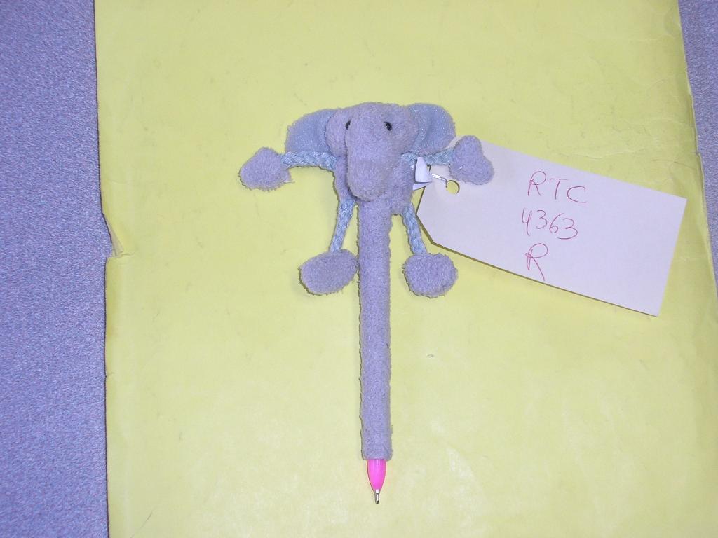 STYLO A BILLE AVEC UNE CARTOUCHE NON REMPLACABLE RECOUVERT DE TISSU ET AVEC UNE PELUCHE EN FORME DE TETE D'ELEPHANT SUR LE DESSUS.