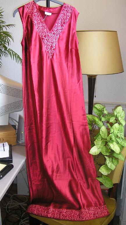 CHEMISE DE NUIT LONGUE POUR FEMME EN TISSU DE FIBRES SYNTHETIQUES, SATINE, 100% POLYESTER, DESTINEE A COUVRIR LE CORPS, DESCENDANT JUSQU’AUX CHEVILLES, DE COUPE TRES AMPLE, AVEC UNE ENCOLURE EN V, SANS MANCHES, AVEC UN PLASTRON EN DENTELLE AUTOUR DE L’ENCOLURE, AVEC UN GALON EN DENTELLE A LA BASE.

LE POURTOUR DE L’ENCOLURE, DES EMMANCHURES ET LA BASE DU VETEMENT SONT DOTES D’UN BIAIS DE FINITION EN SATIN.