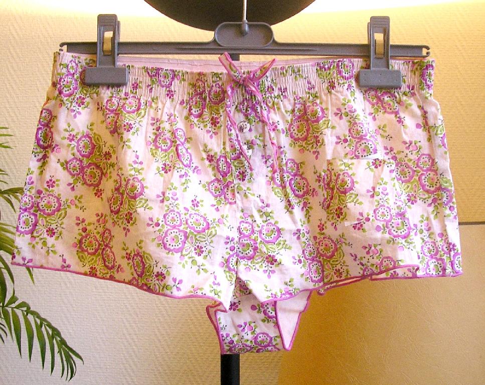 SOUS-VETEMENT SOUS FORME D’UNE CULOTTE, EN TISSU DE COTON (100% COTON) DE TYPE BOXER, DESTINE A COUVRIR LA PARTIE INFERIEURE DU CORPS JUSQ'AU-DESSUS DE LA MI-CUISSE, COMPORTANT UNE BANDE ÉLASTIQUEE À LA TAILLE, UNE DOUBLURE À L'ENTRE-JAMBE, AVEC SUR LE DEVANT UNE PIQURE FORMANT UNE BRAGUETTE OU SONT COUSUS DEUX PETITS BOUTONS, AVEC UN PETITE NŒUD DECORATIF AU NIVEAU DE LA TAILLE, AVEC UN BORD ROULOTTE A LA BASE.