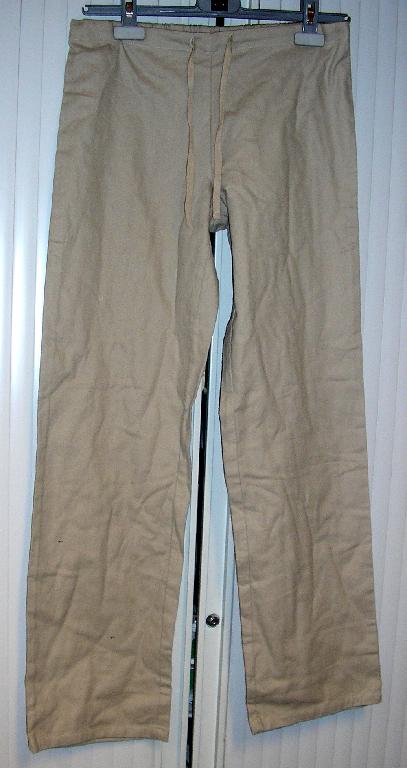 ENSEMBLE POUR FEMMES COMPOSÉ D'UN PANTALON ET D'UN VÊTEMENT DESTINÉ À RECOUVRIR LA PARTIE SUPÉRIEURE DU CORPS DE TYPE BLOUSE RÉALISÉS DANS LE MÊME TISSU DE COTON, TEINT UNIFORMÉMENT, CONDITIONNÉS ENSEMBLE POUR LA VENTE AU DÉTAIL : 

- LE PANTALON EST DE COUPE DROITE ET DESCEND JUSQU'AUX CHEVILLES. IL COMPORTE UNE TAILLE ÉLASTIQUÉE DANS LE DOS AINSI QU'UN CORDON COULISSANT À NOUER SUR LE DEVANT ET UN OURLET À LA BASE.

- LA BLOUSE DESCEND JUSQU'AU-DESSOUS DES HANCHES ET PRÉSENTE UN COL CHEMISE, UNE ENCOLURE EN V DE TYPE MARINIÈRE, DES PINCES POITRINE, DES MANCHES LONGUES ET DES FENTES LATÉRALES D'UNE LONGUEUR DE 7 CM À LA BASE.
CE VÊTEMENT PRÉSENTE UN GALON DE COULEUR CONTRASTÉE SUR LE POURTOUR DU COL, DE L'ENCOLURE AINSI QU'AU NIVEAU DES POIGNETS À ENVIRON 8,5 CM DE L'EXTRÉMITÉ DES MANCHES.
EN OUTRE, CETTE BLOUSE PRÉSENTE UNE SURPIQÛRE HORIZONTALE À 11 CM DE LA BASE ET UN OURLET À LA BASE.

LES COMPOSANTS DE L'ENSEMBLE SONT DE MÊME STRUCTURE, STYLE, COULEUR ET COMPOSITION.