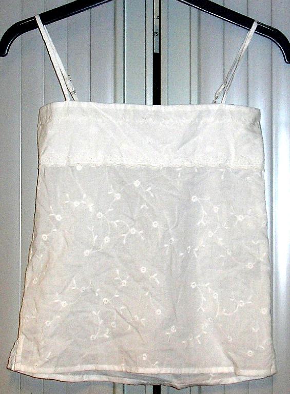 ENSEMBLE POUR FILLETTES COMPOSÉ D'UN SHORT ET D'UN VÊTEMENT DESTINÉ À RECOUVRIR LA PARTIE SUPÉRIEURE DU CORPS GENRE BLOUSE RÉALISÉS DANS LE MÊME TISSU DE COTON, DE TYPE BRODERIE ANGLAISE, TEINT UNIFORMÉMENT ET CONDITIONNÉS ENSEMBLE POUR LA VENTE AU DÉTAIL : 

- LE SHORT EST DE COUPE DROITE ET COMPORTE UNE TAILLE ÉLASTIQUÉE, DE PETITES FENTES LATÉRALES (SUR UNE LONGUEUR DE 3 CM) AINSI QU'UN OURLET À LA BASE.

- LA BLOUSE DESCEND JUSQU'AUX HANCHES ET PRÉSENTE UNE ENCOLURE DROITE, DE FINES BRETELLES RÉGLABLES ET UNE BANDE DE TISSU RAPPORTÉE SUR LE DEVANT AU NIVEAU DE LA POITRINE. LA PARTIE SUPÉRIEURE DU DOS EST SMOCKÉE ET ÉLASTIQUÉE.
EN OUTRE, CETTE BLOUSE PRÉSENTE DE PETITES FENTES LATÉRALES (SUR UNE LONGUEUR DE 4 CM) AINSI QU'UN OURLET À LA BASE.

LES COMPOSANTS DE L'ENSEMBLE SONT DE MÊME STRUCTURE, STYLE, COULEUR ET COMPOSITION.