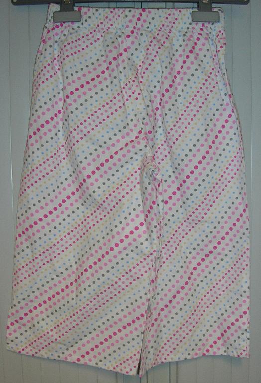 ENSEMBLE DE DEUX VÊTEMENTS POUR FILLETTES, CONDITIONNÉS ENSEMBLE POUR LA VENTE AU DÉTAIL ET CONFECTIONNÉS DANS LE MÊME TISSU DE COTON IMPRIMÉ, COMPRENANT:

- UN VÊTEMENT DESTINÉ À RECOUVRIR LA PARTIE SUPÉRIEURE DU CORPS,  AVEC UNE ENCOLURE ARRONDIE, AVEC UNE OUVERTURE PARTIELLE SUR LE DEVANT FERMÉE AU MOYEN D'UN BOUTON DROITE SUR GAUCHE, AVEC UN ÉLASTIQUE AU NIVEAU DE L'ENCOLURE, AVEC DES MANCHES 3/4 RESSERRÉES À LEUR EXTRÉMITÉ AU MOYEN D'UN ÉLASTIQUE, AVEC DEUX FENTES LATÉRALES DE 8 CM ENVIRON À LA BASE, AVEC UN OURLET À LA BASE ET À L'EXTRÉMITÉ DES MANCHES. 

- UN PANTALON ARRIVANT AUX MOLLETS, COMPORTANT UNE BANDE ÉLASTIQUE À LA TAILLE AINSI QU'UNE FENTE LATÉRALE (LONGUEUR : 8 CM) ET UN OURLET À L'EXTRÉMITÉ DE CHAQUE JAMBE.